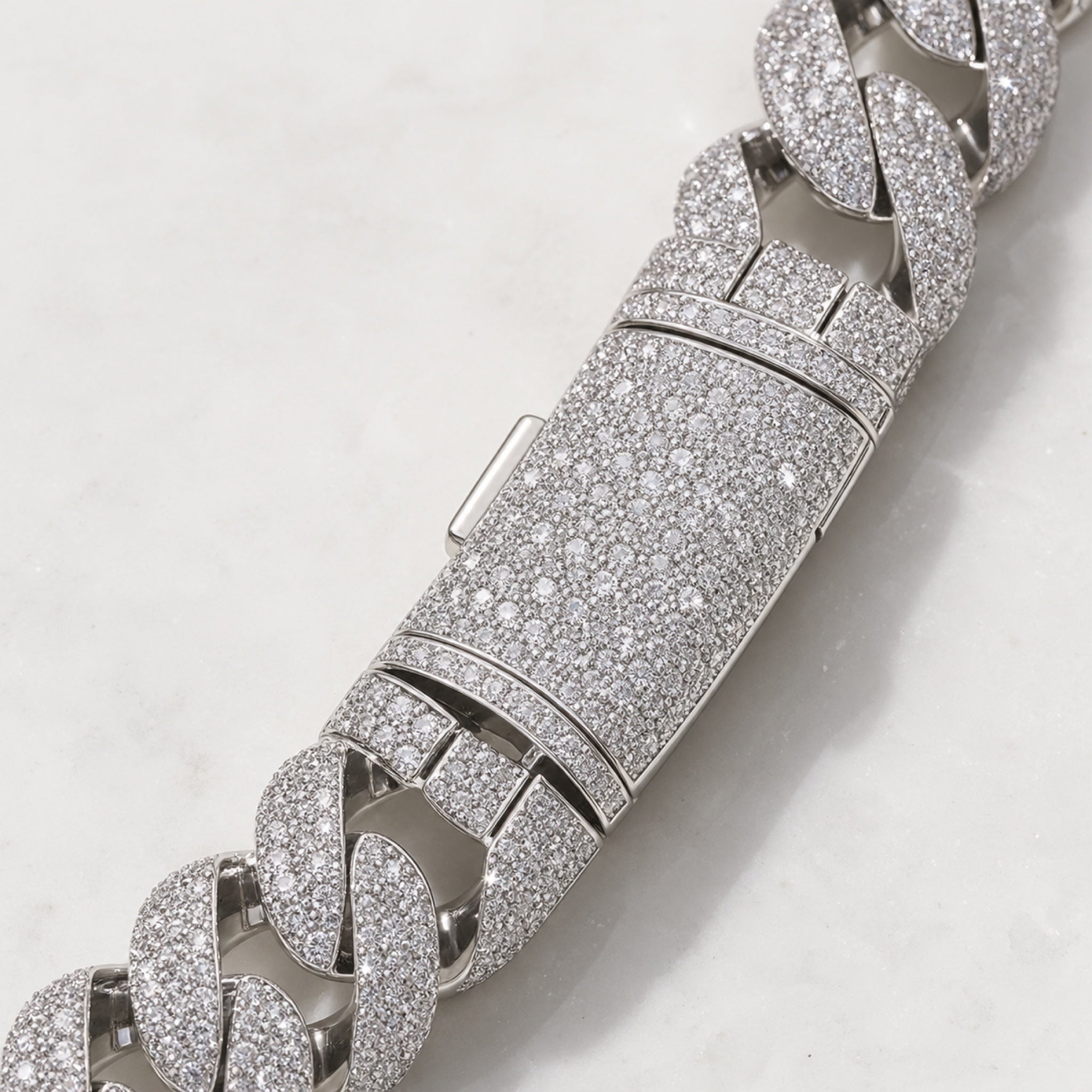 Close-up of the curved flip-buckle clasp on the 22 mm iced Cuban chain
