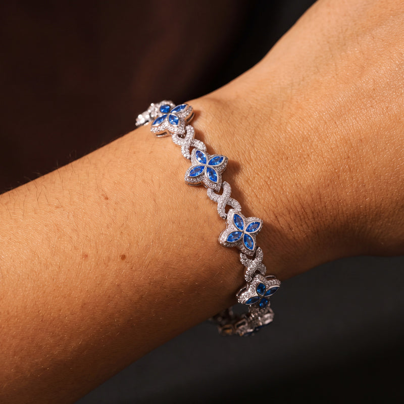 Silver-tone clover flower bracelet with deep blue marquise petals, worn on a wrist