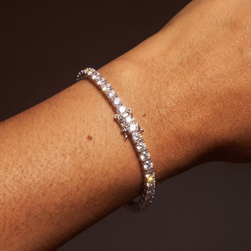 Cubic zirconia tennis bracelet worn on a wrist, single row of four-prong set round stones