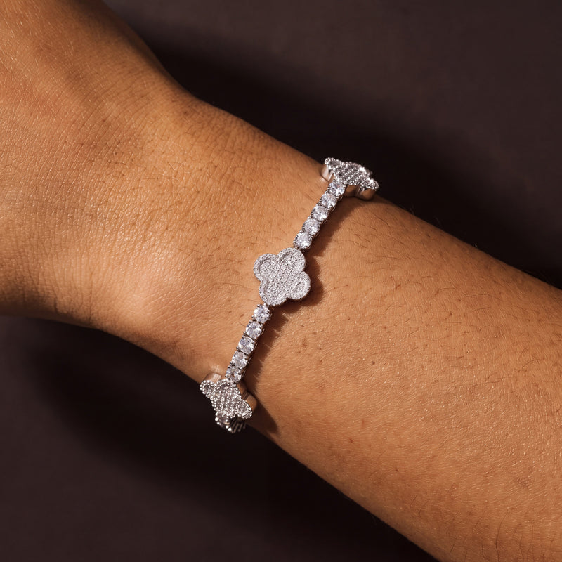 Silver-tone four-leaf clover tennis bracelet worn on a wrist